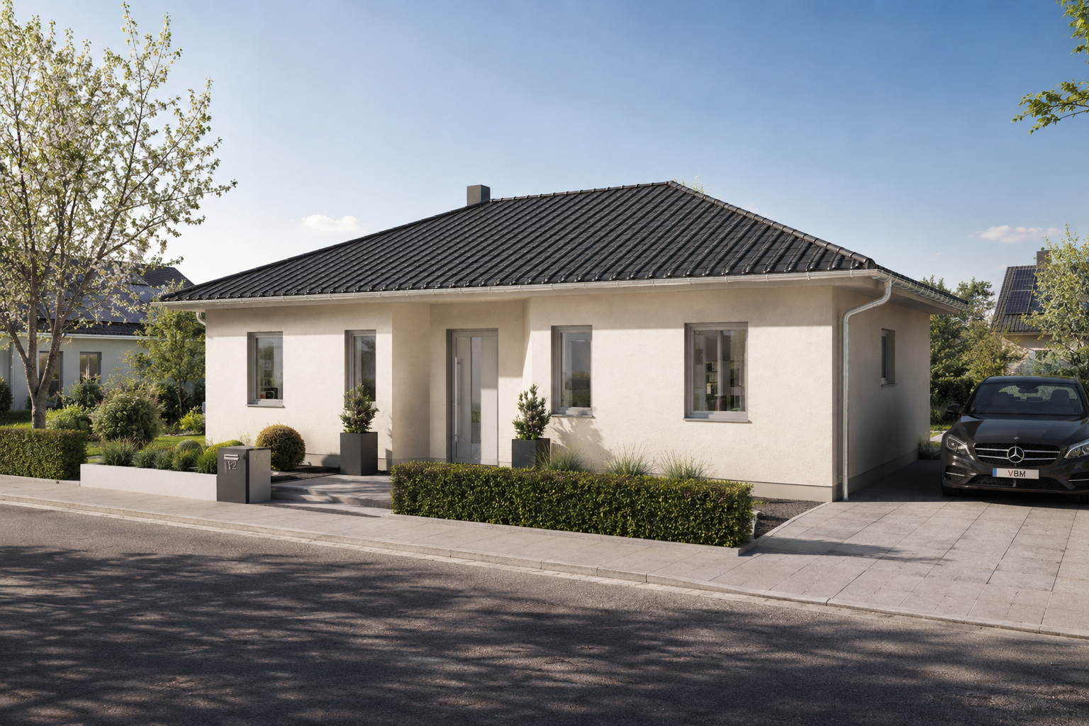 Ein modernes, einstöckiges Haus – ideal für alle, die einen Bungalow bauen möchten – mit cremefarbenen Wänden und einem dunklen Ziegeldach steht inmitten einer gepflegten Gartenanlage. In der Einfahrt steht ein schwarzes Auto, während Bäume und Sträucher die Straße unter einem strahlend blauen Himmel säumen.